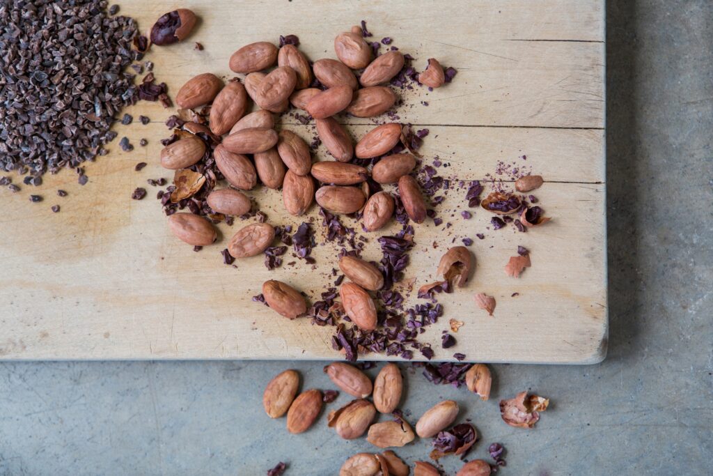 Cocoa beans on a brown chopping board