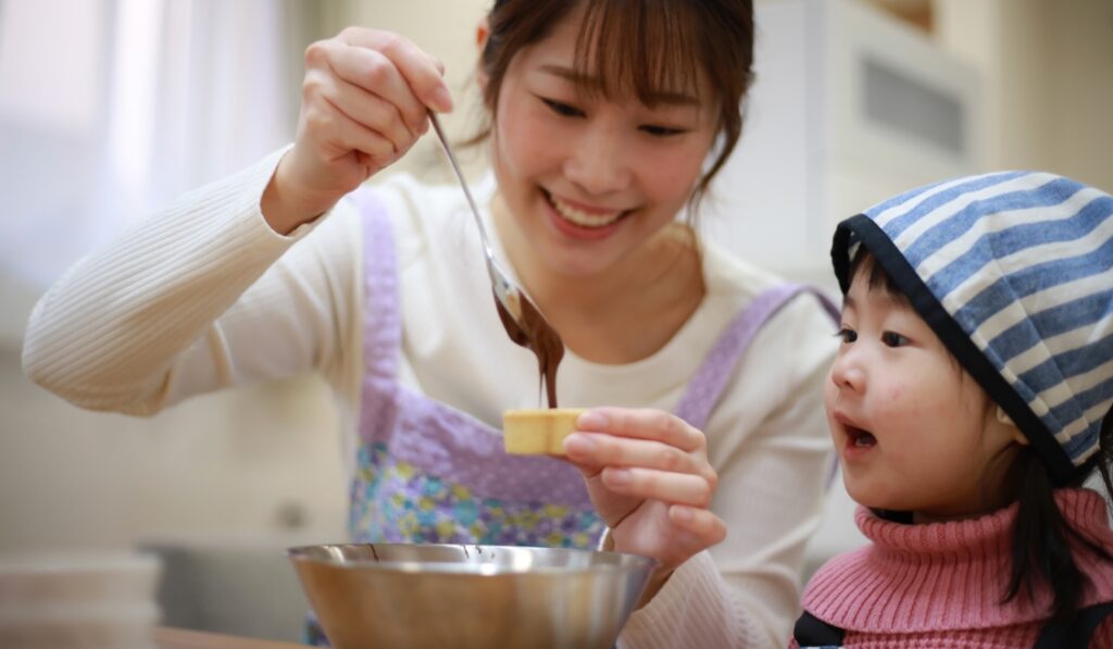 A mum and daughter pouring melted chocolate into a mould